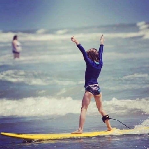 Student celebrating a ride with arms raised, seen from behind